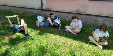 Dzieci czytają przed szkołą